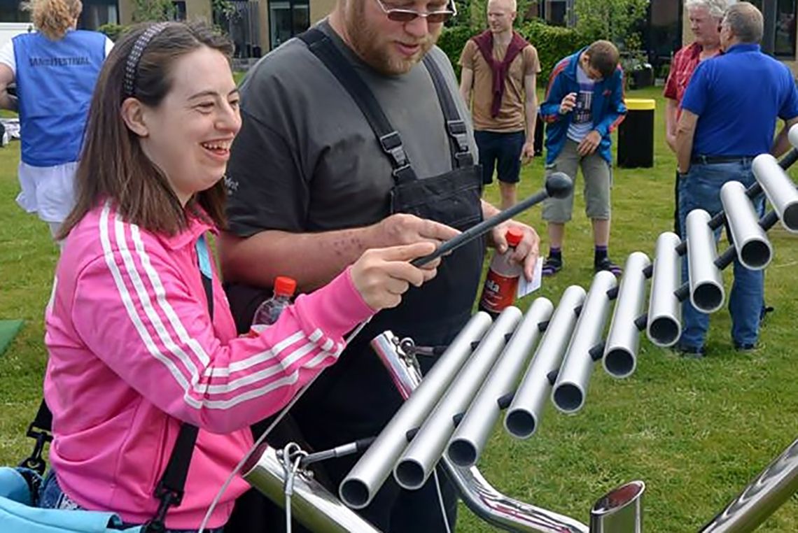 girl with special needs playing a large outdoor xylophone