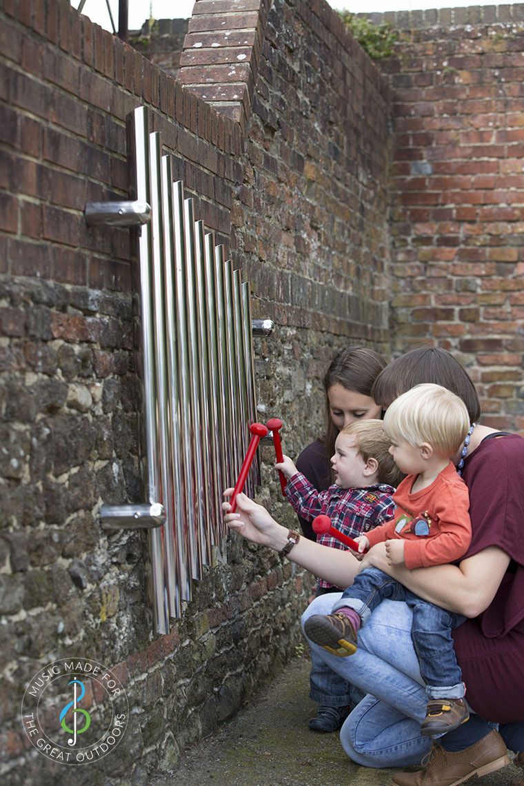 mother and child playing mirrored wall chimes together