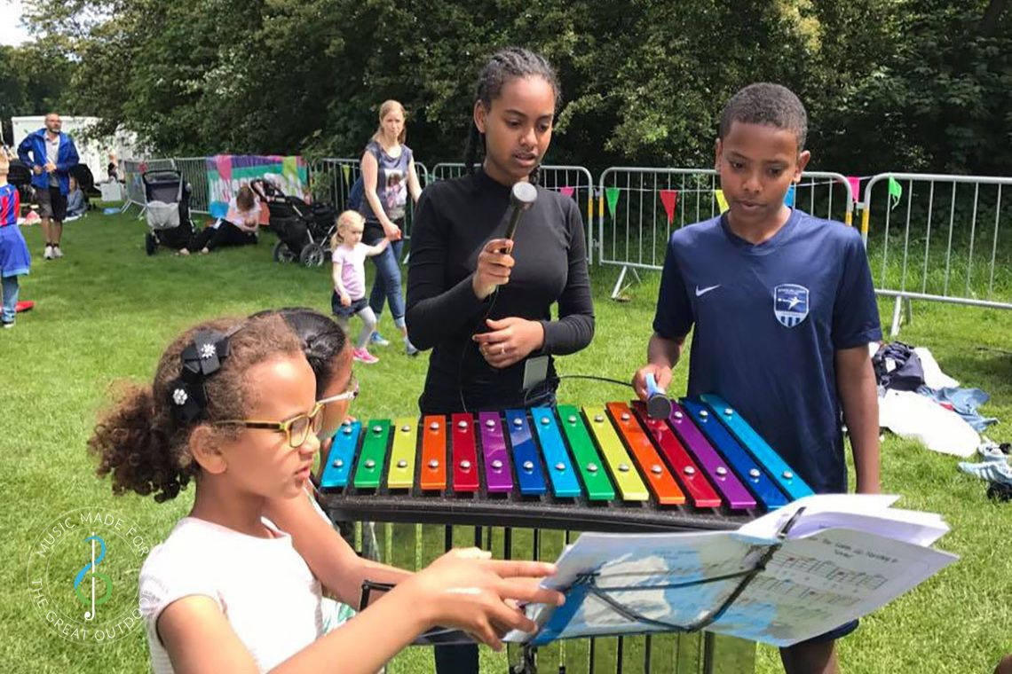 Children Playing Rainbow Coloured Outdoor Xylophone in Park